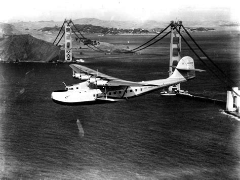 China Clipper taking off for the Orient passing over the unfinished Golden Gate Bridge. 1930's ...