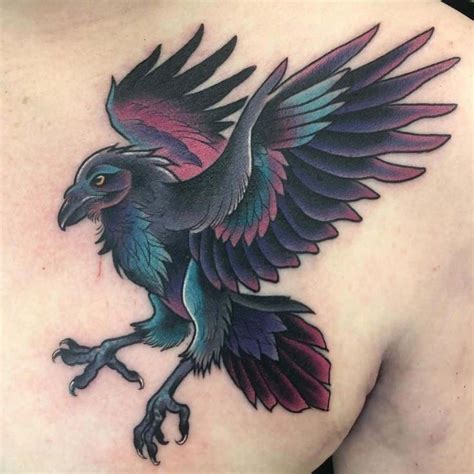 a bird tattoo on the back of a woman's shoulder, with purple and blue ...