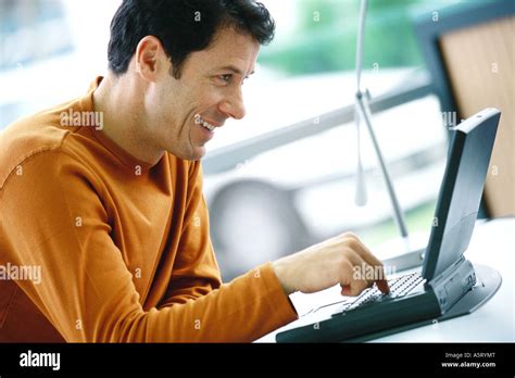 Man using laptop, smiling Stock Photo - Alamy