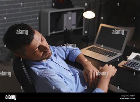 Sleeping man in office at night Stock Photo - Alamy