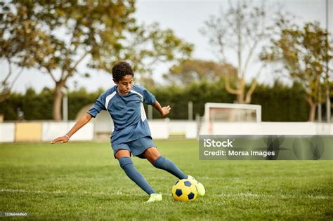 Teenage Boy Kicking Soccer Ball In Field Stock Photo - Download Image Now - Soccer, Child ...