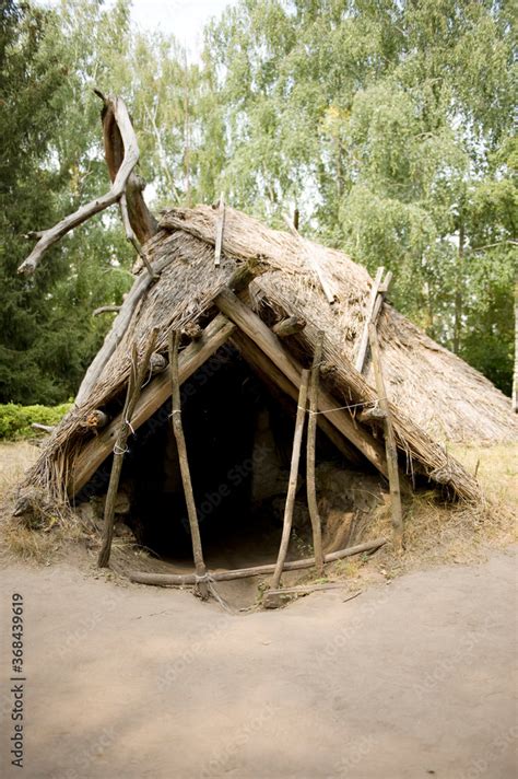 Reconstruction of a hut of a primitive man of the Stone Age, a dugout ...