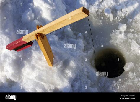 A trap setup for ice fishing on a river Stock Photo - Alamy