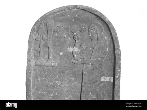 Bel Haran Beli Usur is praying in front of divine symbols. Stele with inscription and relief ...