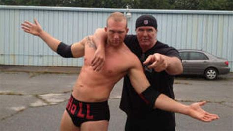 two men standing next to each other in a parking lot