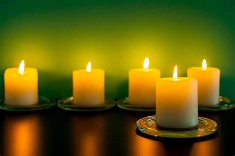 Premium Photo | Colorful scented candles on a dark green