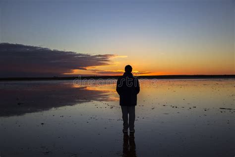 Silhouette of Man Staring into Sunset Reflected in Shallow Lake. Stock Photo - Image of ...