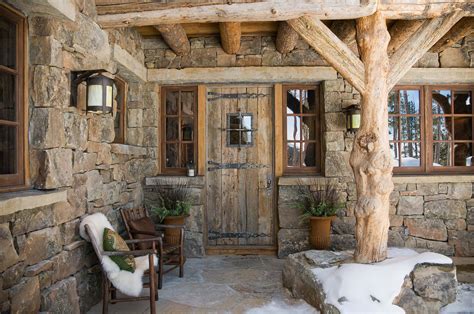 Beautiful cabin entry. Rock walls, rustic lighting, small wooden windows, natural wood porch ...