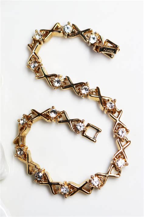 This vintage bracelet is classic Avon with highly polished Xs and Rhinestone Os that are linked ...