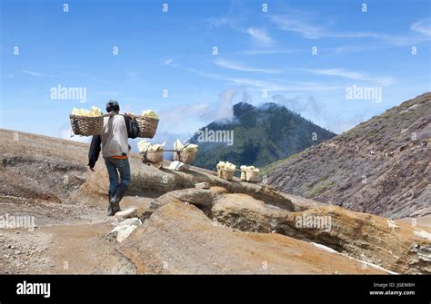 Workers carrying baskets of Sulphur rock from volcano Stock Photo - Alamy