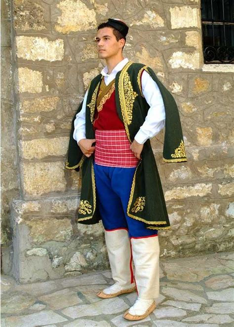 a man dressed in costume standing next to a stone wall