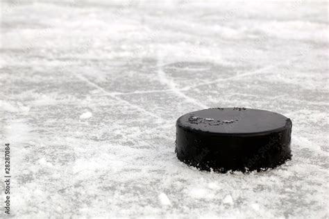 black hockey puck on ice rink Stock Photo | Adobe Stock