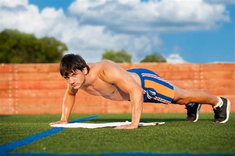 Premium Photo | Outdoor sport fitness training handsome young men doing pushups outdoors in the ...