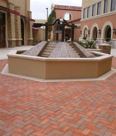 a fountain in the middle of a brick walkway