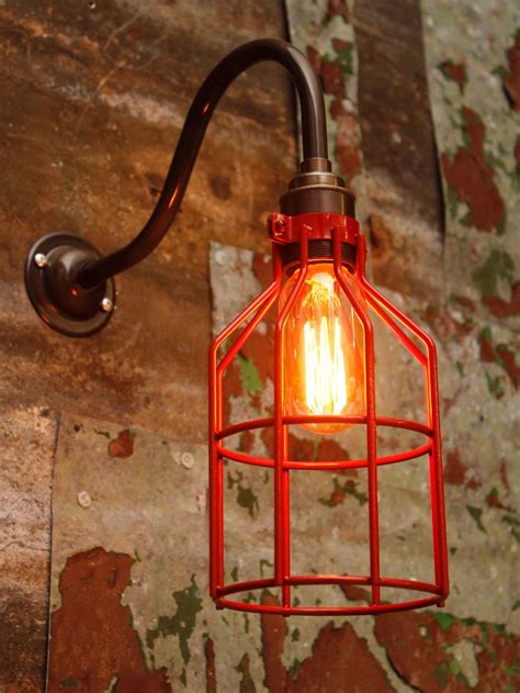 Industrial wall light with antique brass arm and red metal wire cage. Bespoke Lighting, Lighting ...