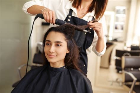 Premium Photo | Hairdresser curls woman's hair, hairdressing salon ...