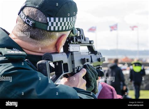 Police officer looks through the sights of a Heckler and Koch G36C ...