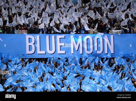 Manchester City fans wave flags ahead of kick-off near a banner that ...