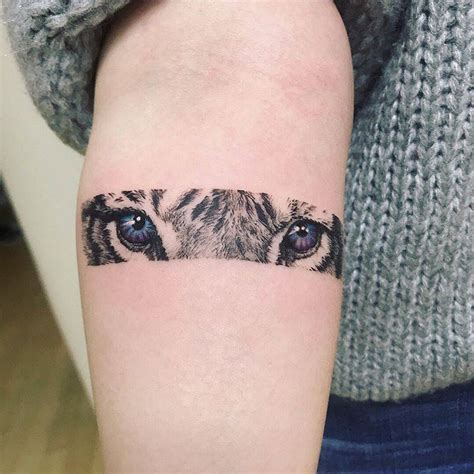 Tiger eyes tattoo on the inner forearm.