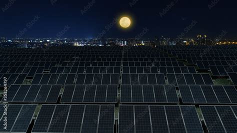 Solar panels power plant at night with full moon and night city ...