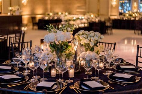 the table is set with white flowers and candles for an elegant dinner or reception party