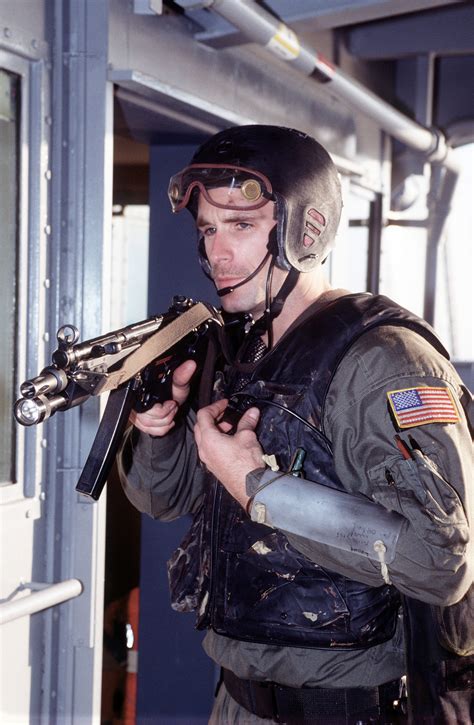 A U.S. Navy SEAL, armed with an MP5-N sub-machine gun, sets up a security perimeter on the upper ...