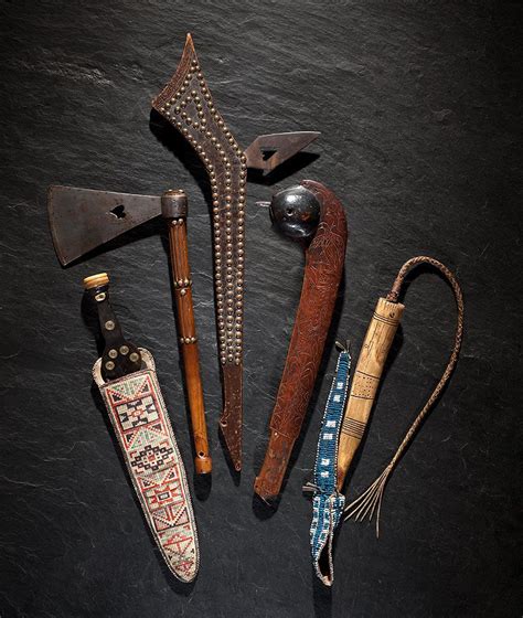 an assortment of old tools are laid out on a black surface, including ...