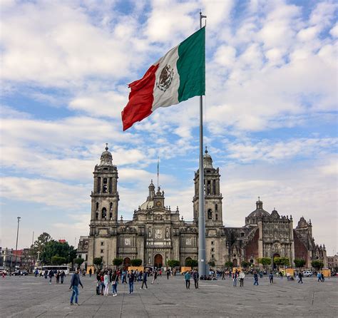 the mexican flag is flying in front of an old building