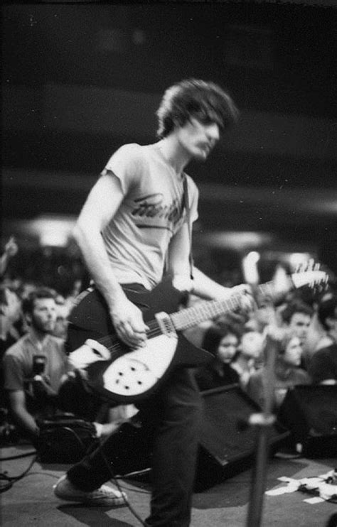 black and white photograph of man playing guitar in front of audience