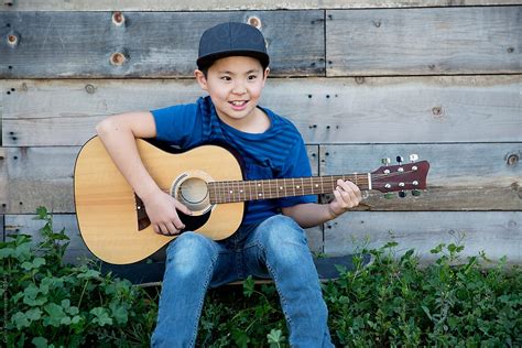 "Asian Boy Playing Guitar And Smiling" by Stocksy Contributor "Curtis ...