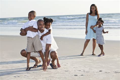 Family with three children playing at the beach - Your Future Group ...