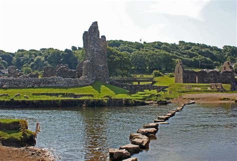 Stepping stones lead across the River Ogmore to the ruins of Ogmore Castle in Vale of Glamorgan ...