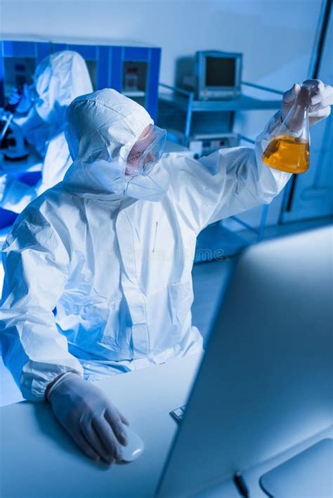 Scientist in Hazmat Suit Holding Flask Stock Image - Image of orange ...