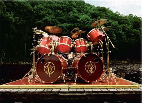 Neil Peart playing his classic red Tama Superstar. Outside. On a raft ...