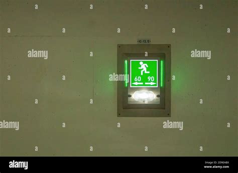 Green sign emergency exit 60 90 in a tunnel Stock Photo - Alamy