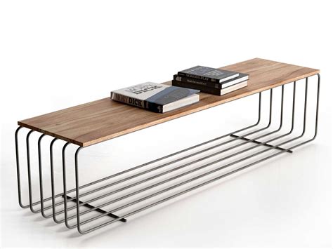 three books are stacked on top of each other near a wooden table with metal legs