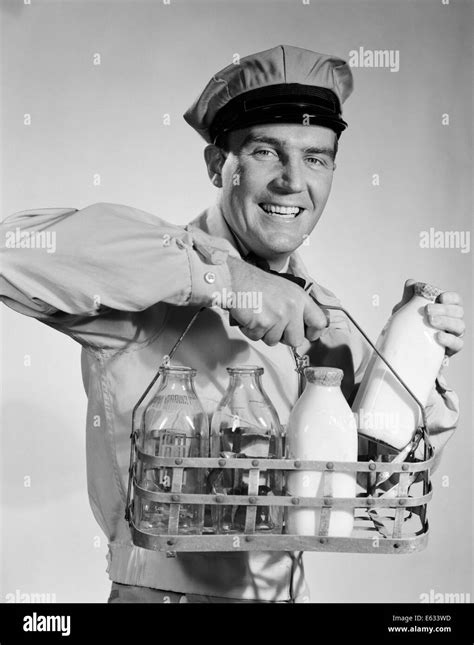 1950s 1960s SMILING MILKMAN IN UNIFORM LOOKING AT CAMERA CARRYING TWO Stock Photo, Royalty Free ...