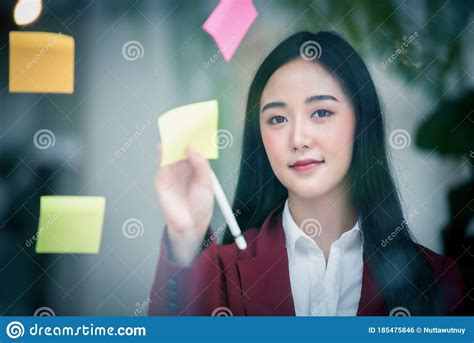 Portrait of Young Asian Businesswoman Writing Sticky Paper Pad on Glass in Modern Office ...