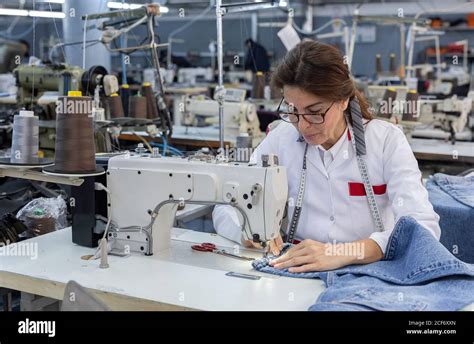 Working Woman hands in textile factory sewing on industrial sewing ...