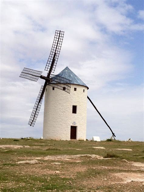 a white windmill sitting on top of a lush green field