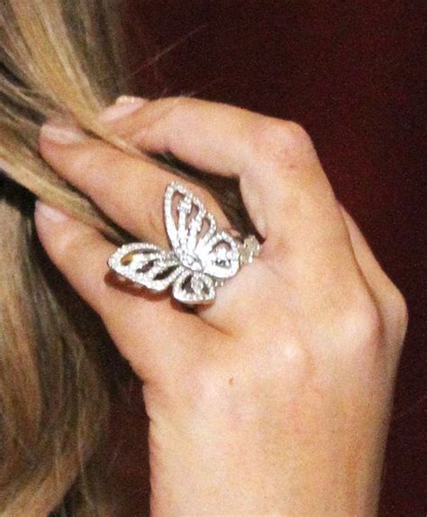 a close up of a person wearing a butterfly ring