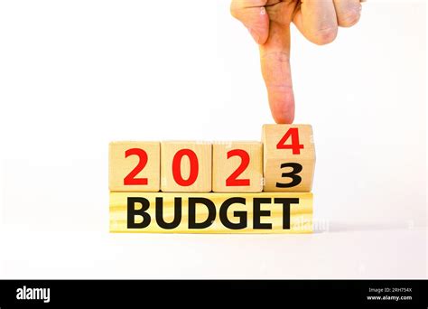 Planning 2024 budget new year symbol. Businessman turns a wooden cube and changes words Budget ...