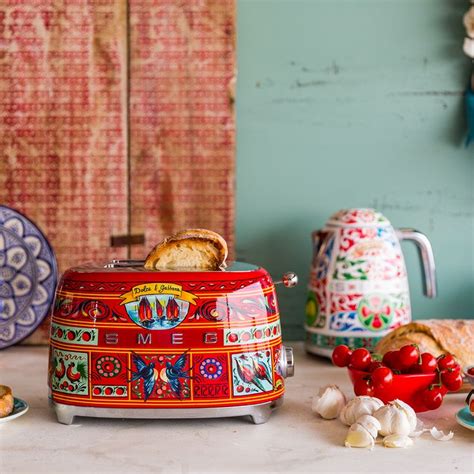 a colorful toaster sitting on top of a counter next to plates and bowls ...