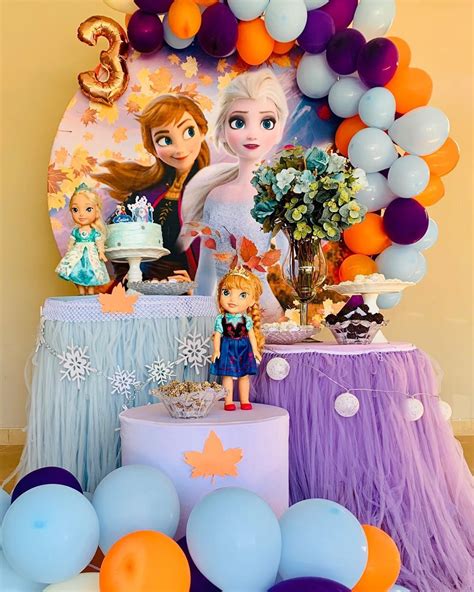 a frozen princess birthday party with balloons, cake and decorations on ...