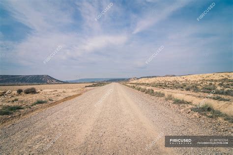 Desert dusty road between abandoned dry area with vegetation in semi-desert — ecology, hot ...