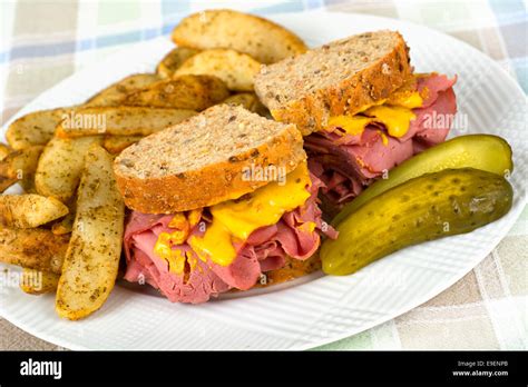 Corned Beef Sandwich Mustard Roasted Potatoes and Pickle on Plate Stock Photo - Alamy