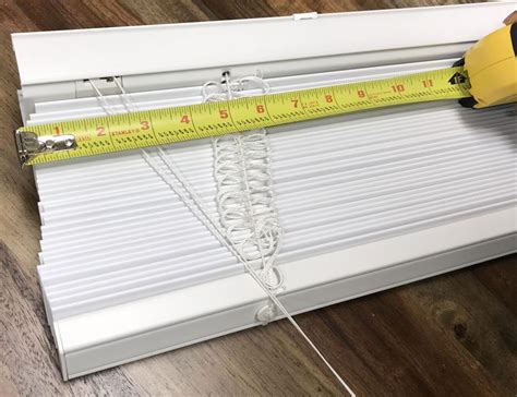 a person measuring the length of a window with a tape measure