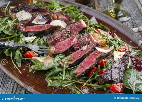 Traditional Italian Tagliata Steak with Parmesan Cheese and Lettuce on ...