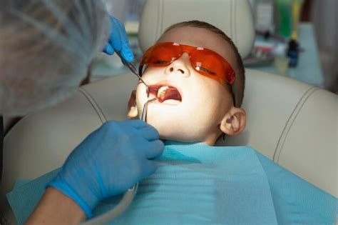 Premium Photo | The boy treats his teeth in the dentist's office hygiene and health closeup