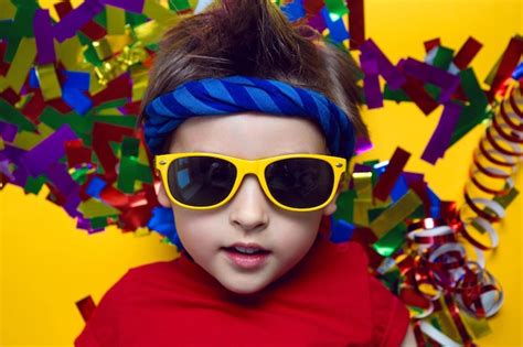 Premium Photo | Child a boy in a red t shirt and sunglasses is lying on yellow paper resting at home